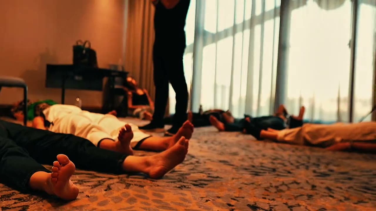 A full hotel hall mid-session at the Sofia night, the room on the floor and Daria walking between them.