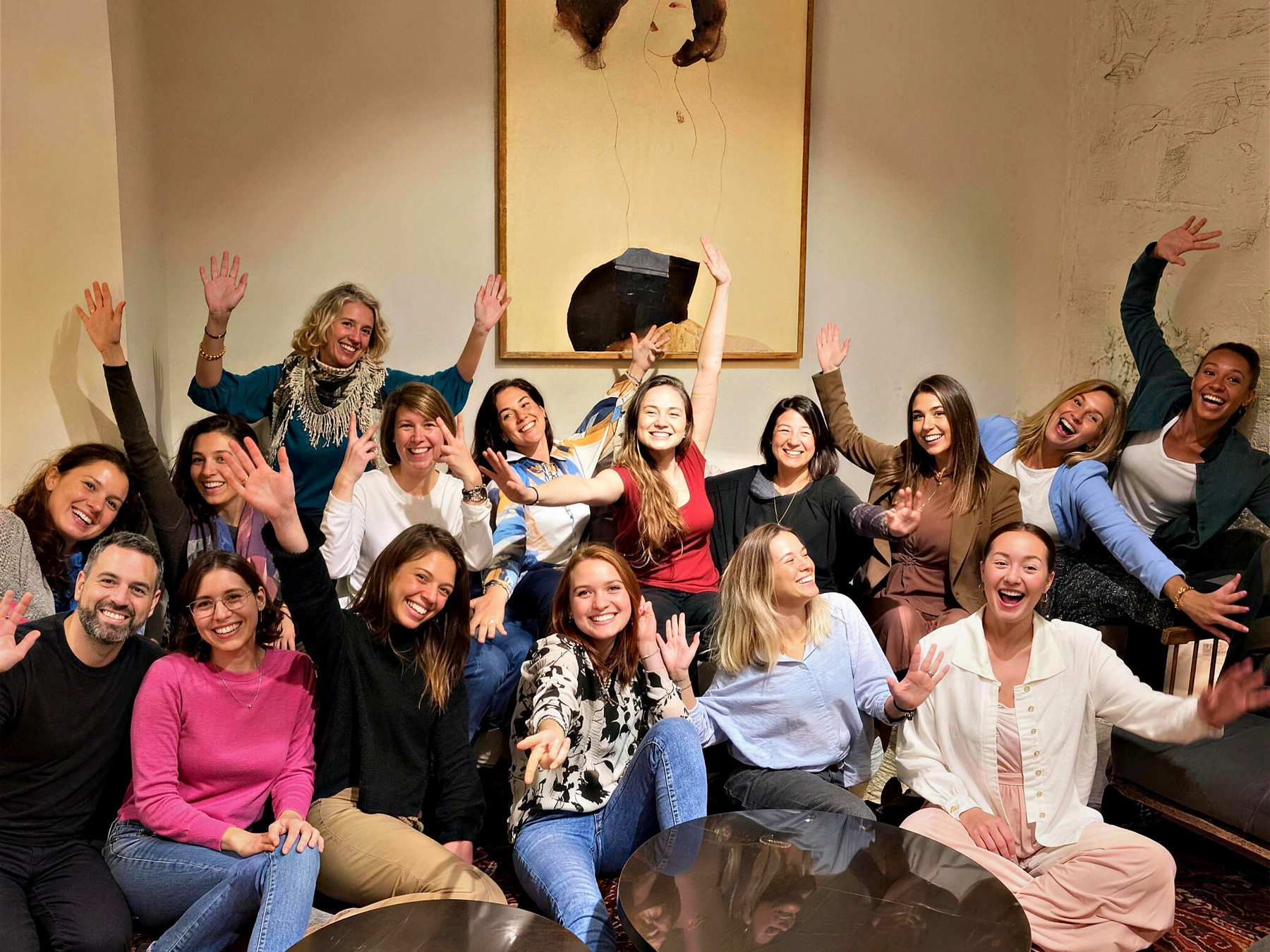 The room at the end of a session: arms up, everyone laughing, Barak at the near edge of the group.