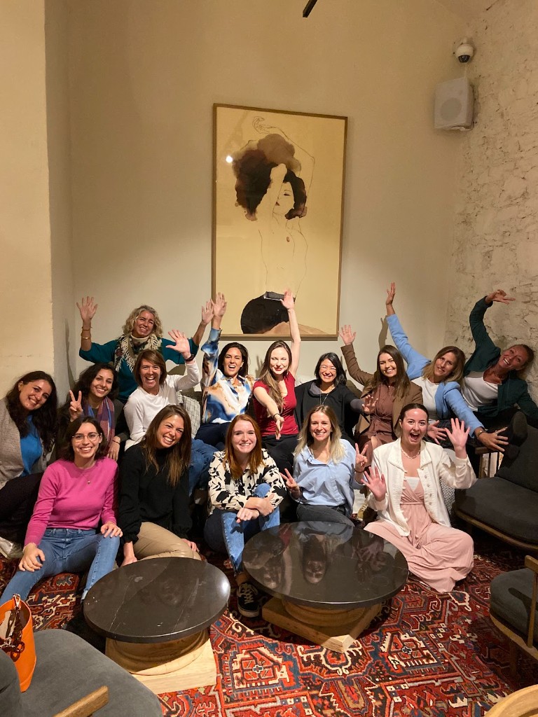A room of women at a Mind Artists live event, arms in the air.